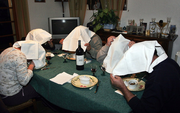 Diners eating ortolan with napkins covering their heads